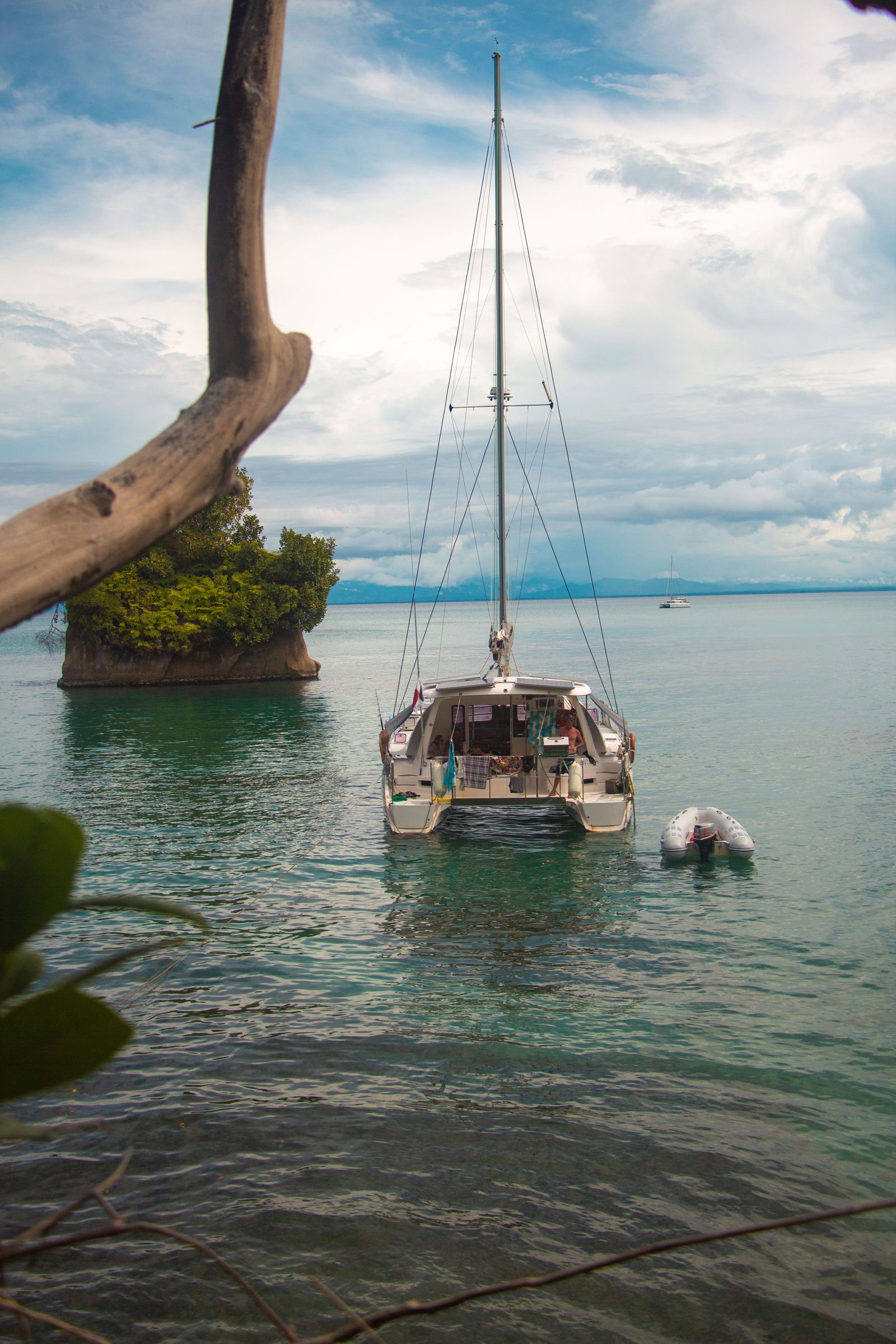 Catamaran anchored near a small mangrove-covered islet
