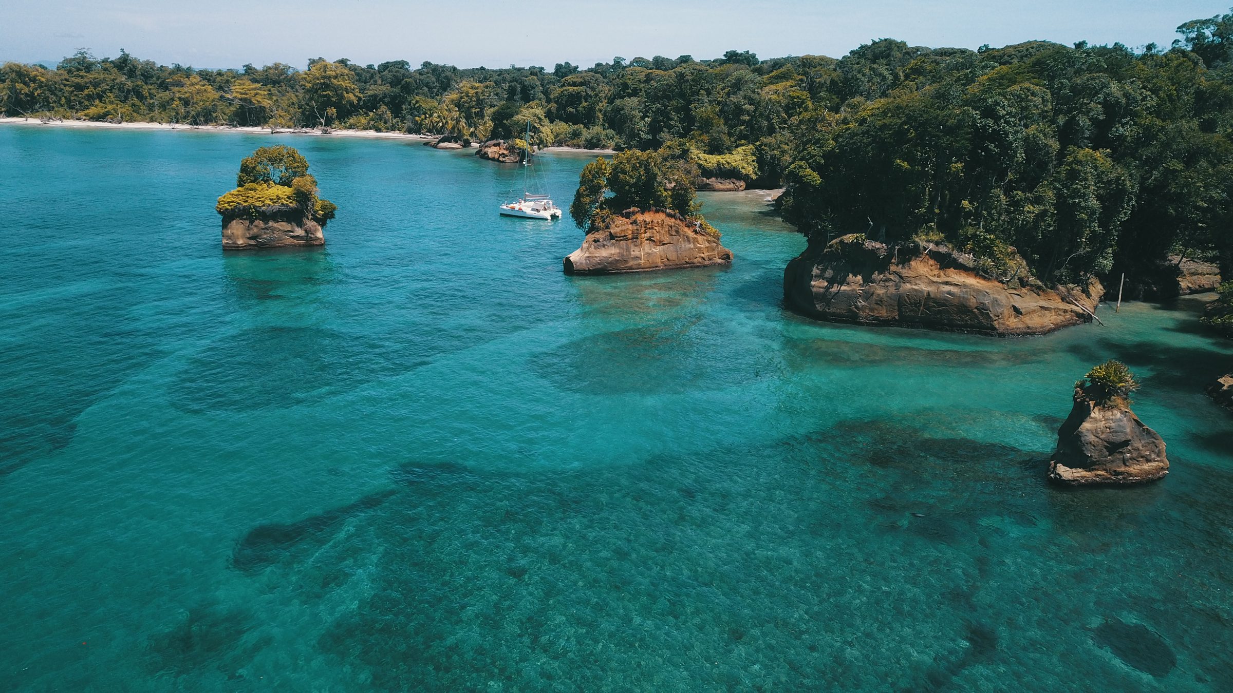 Aerial view of small rock islets rising from turquoise reef water in Bocas del Toro