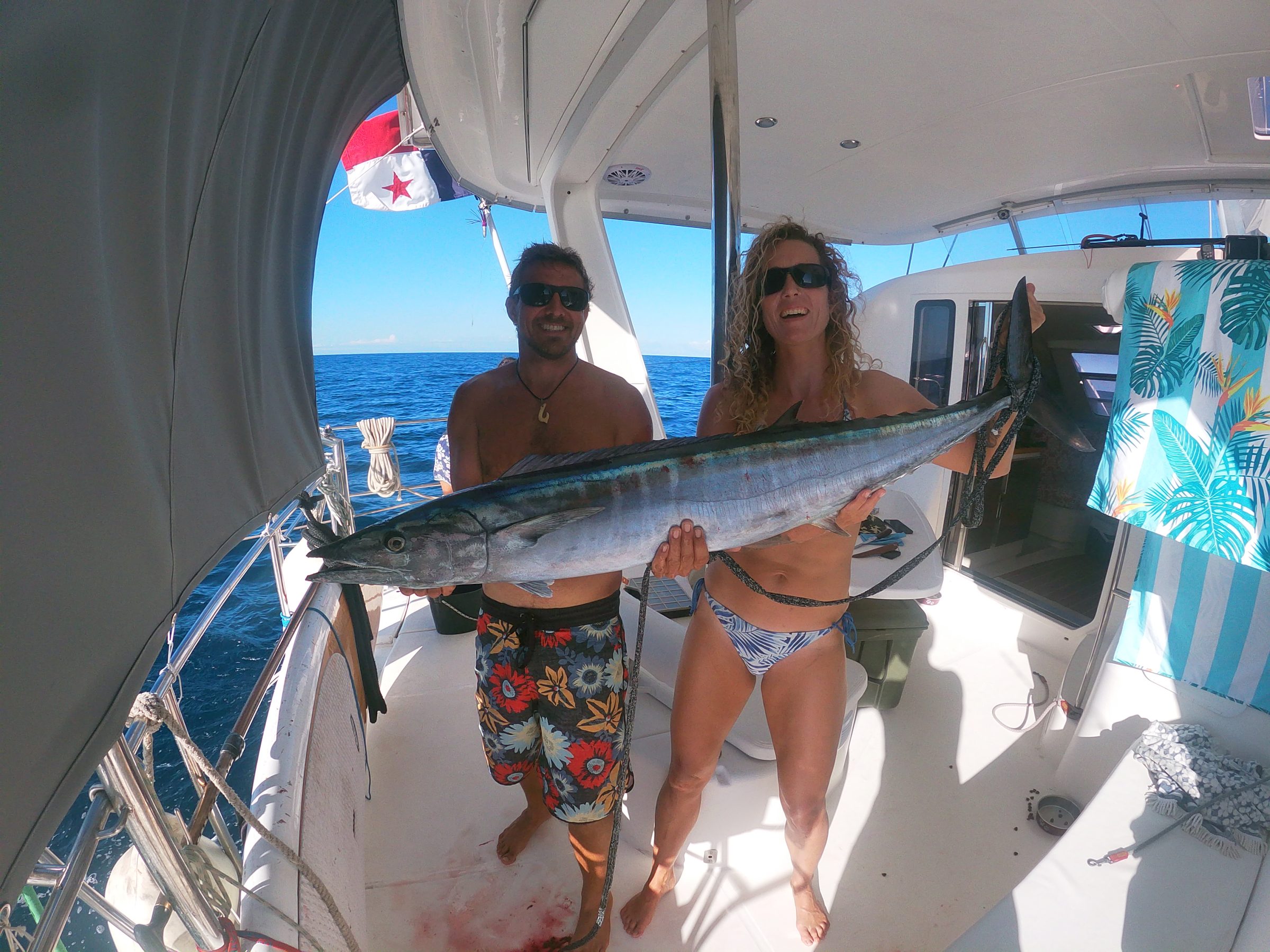 Guests holding a freshly caught wahoo on deck